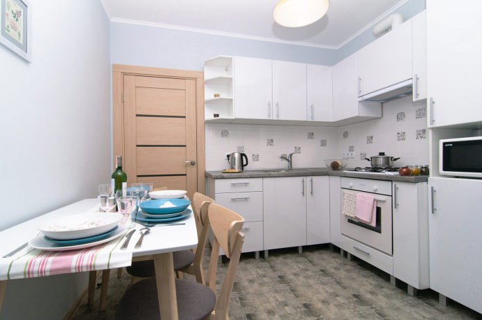 virtuve baltā krāsā studijas tipa dzīvoklī