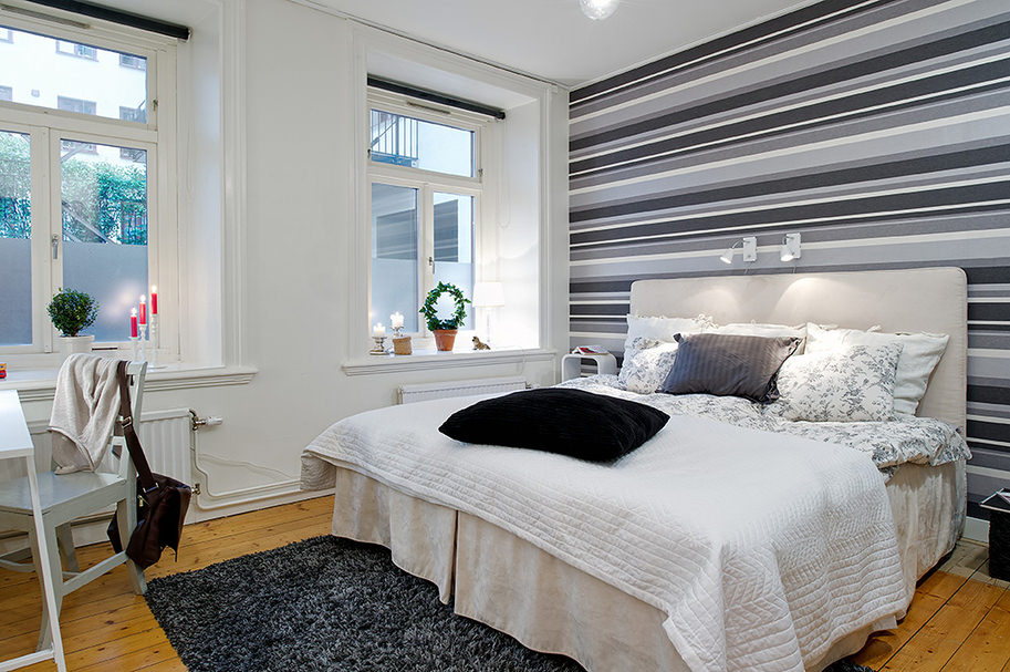 design ložnice s šedými pruhovanými tapetami
