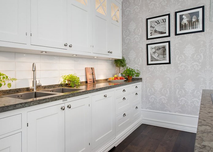 Šviesiai pilkos spalvos tapetai virtuvės interjere su baltu rinkiniu