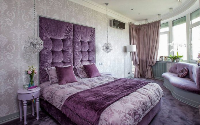 Grijs behang in het interieur van de slaapkamer met paarse meubels en gordijnen