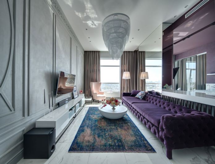 svetainės interjeras su purpurine sofa ir gražiu sietynu
