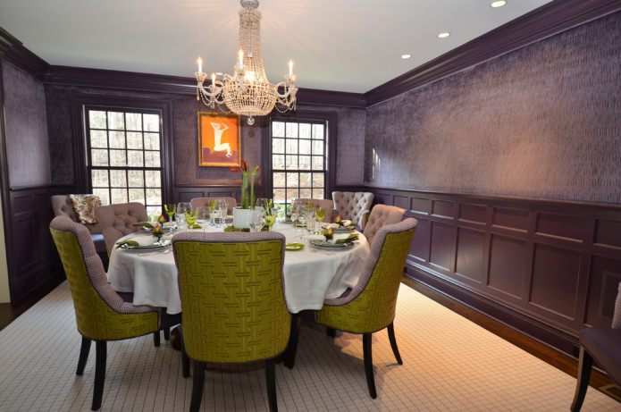 salle à manger avec papier peint violet foncé et chaises vert-lilas