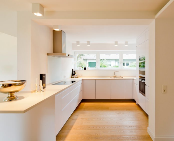 balts virtuves interjers ar vaniļas krāsas darba virsmu