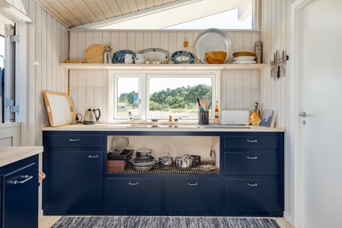 مطبخ أزرق بجدران مغطاة بألواح خشبية