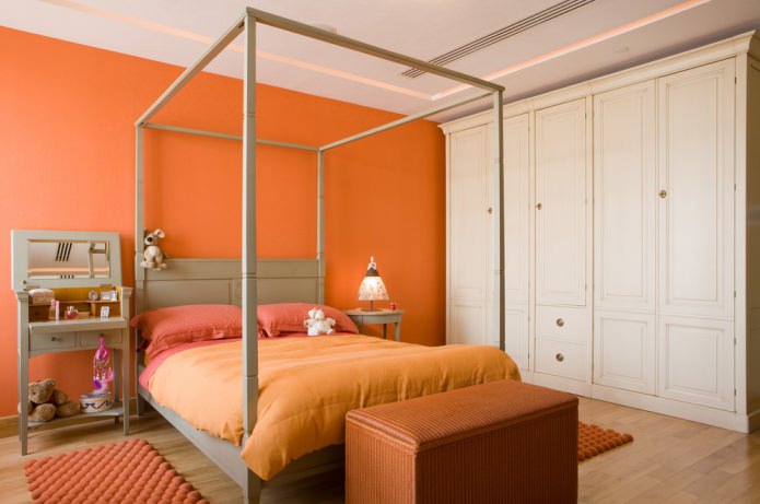 makuuhuone oranssilla seinällä ja tekstiileillä