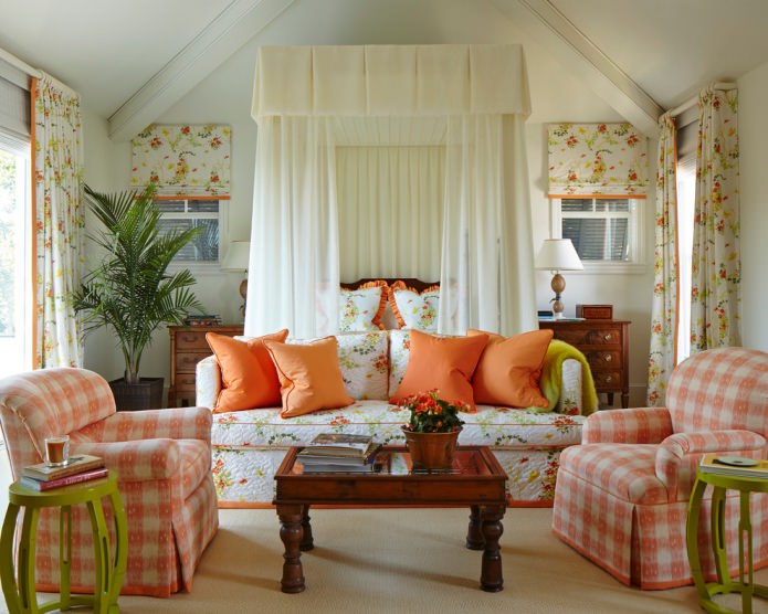 Lauku viesistaba ar oranžiem ziedu tekstilizstrādājumiem