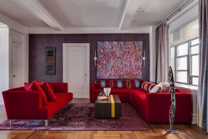 fioletowa tapeta i czerwona sofa z tkaniny