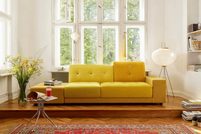 dzeltens dīvāns ar auduma apdari interjerā