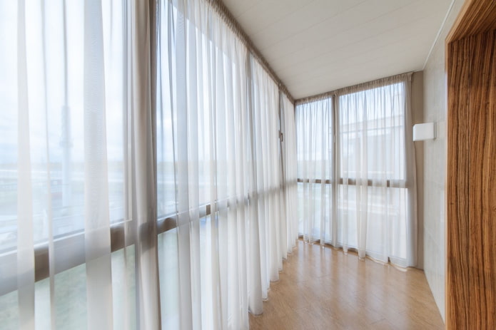cortines de color blanc a l'interior del balcó