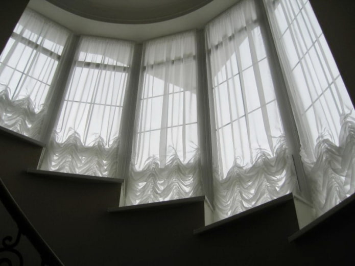 Østrigske gardiner på vinduerne langs trappen