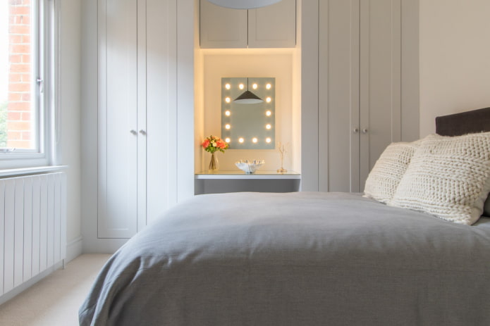 specchio con lampadine perimetrali in camera da letto