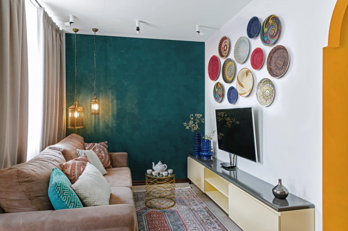 Televizorius ant sienos su dekoratyvinėmis plokštėmis salėje