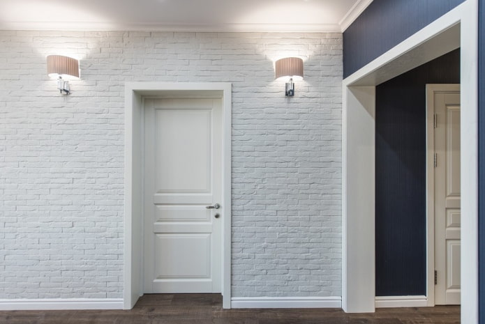 baltas durvis ar baltām grīdlīstēm interjerā