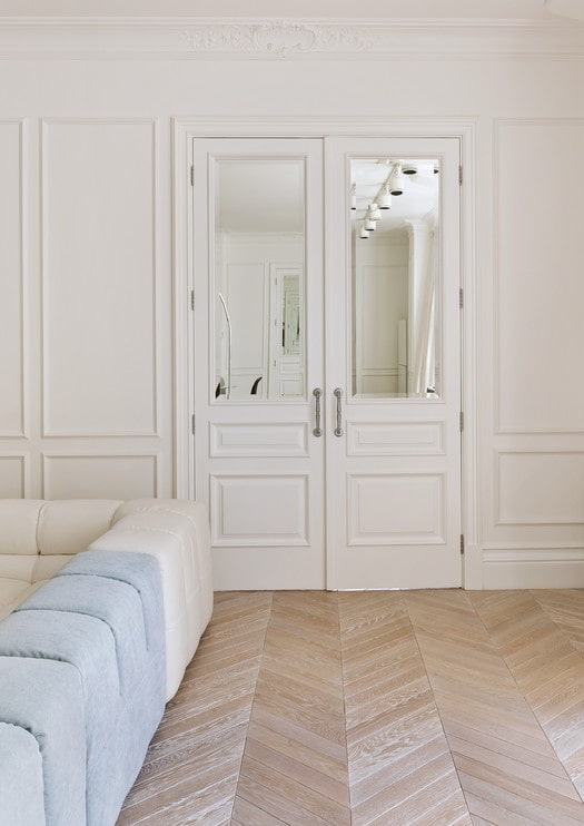 baltas durvis ar spoguļa ieliktņiem interjerā
