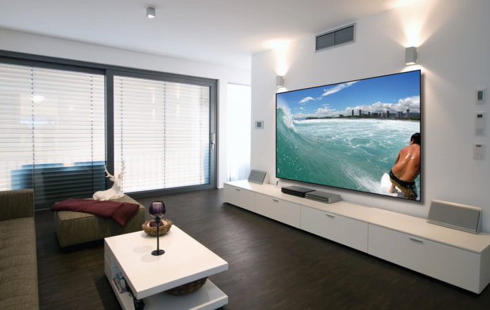 stort vægmonteret tv i det indre af stuen