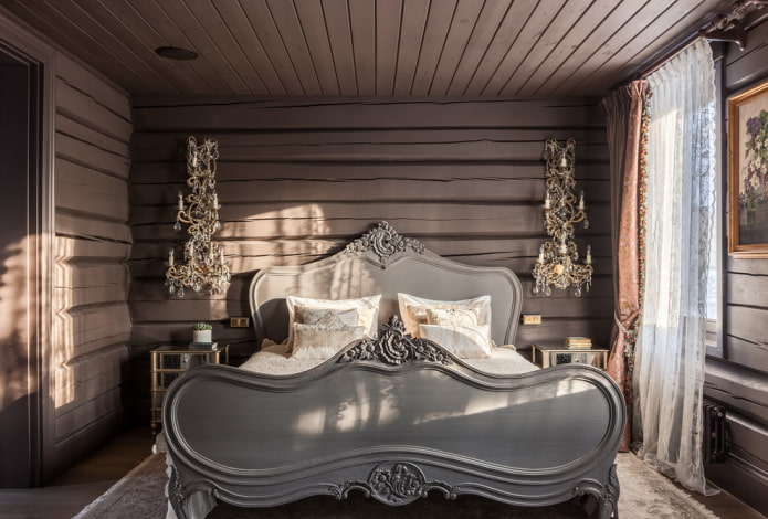 dřevěná postel s vyřezávanými čely v interiéru