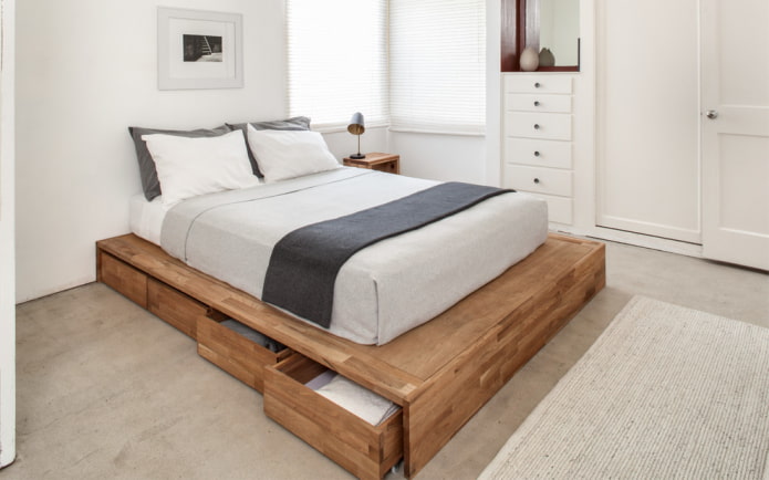 dřevěná postel se zásuvkami v interiéru