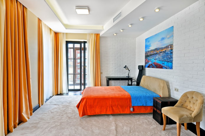 gulta ar oranžu gultas pārklāju guļamistabā
