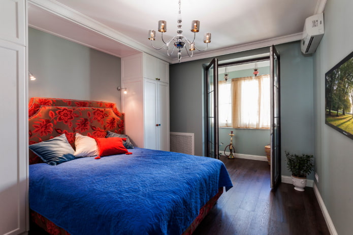 postel s modrým přehozem v ložnici