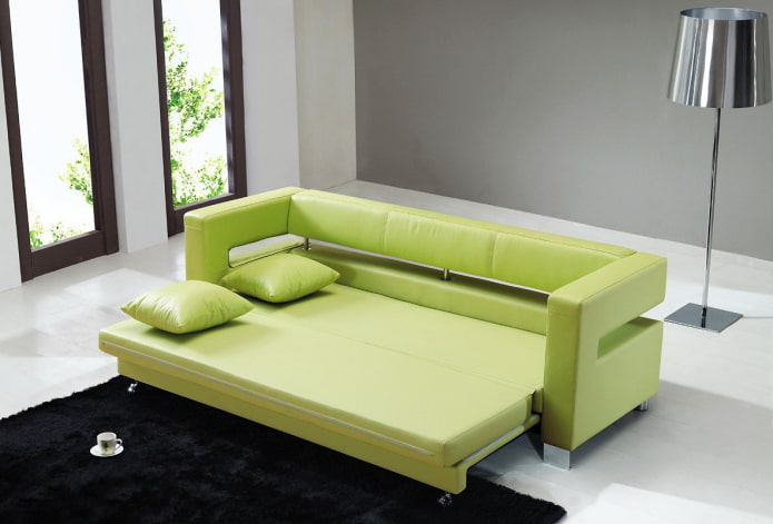 zaļš izvelkamais dīvāns interjerā