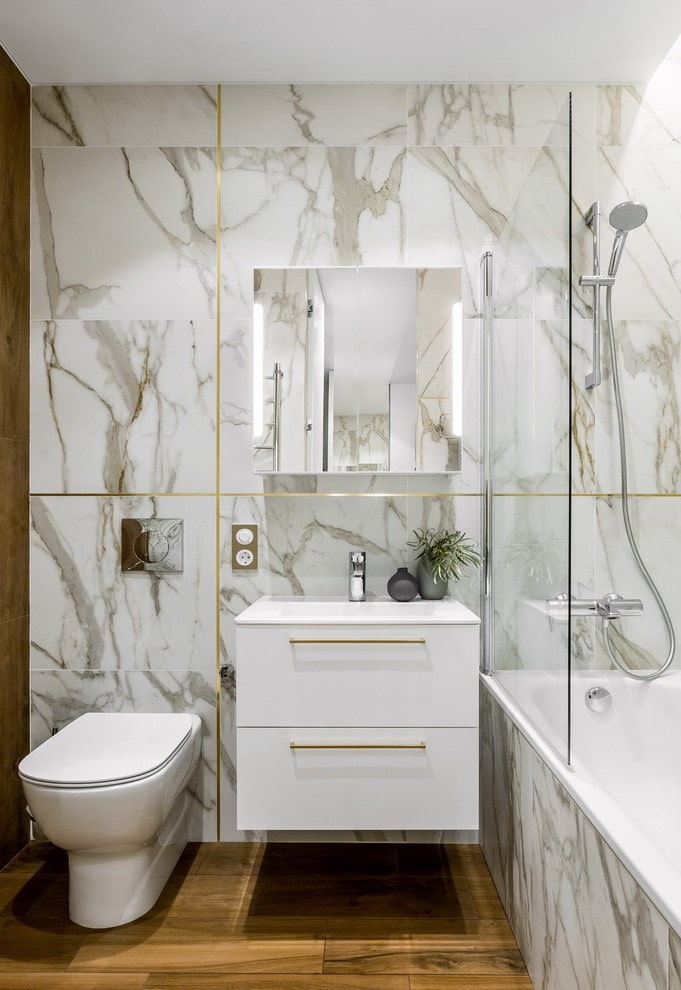 baltas marmora flīzes vannas istabas interjerā