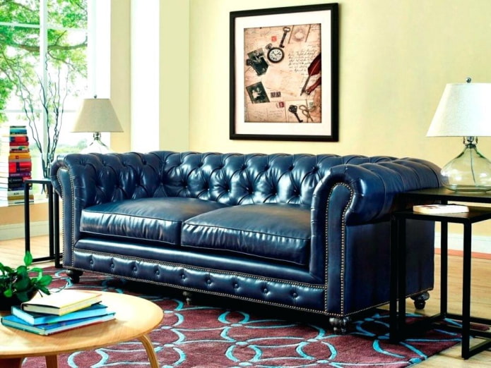 sofa su mėlynos odos apmušalu interjere