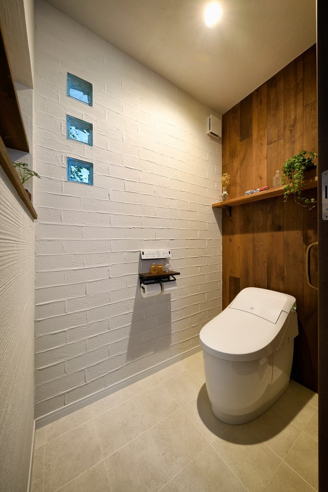 Biała toaleta z drewnianą fałszywą ścianą