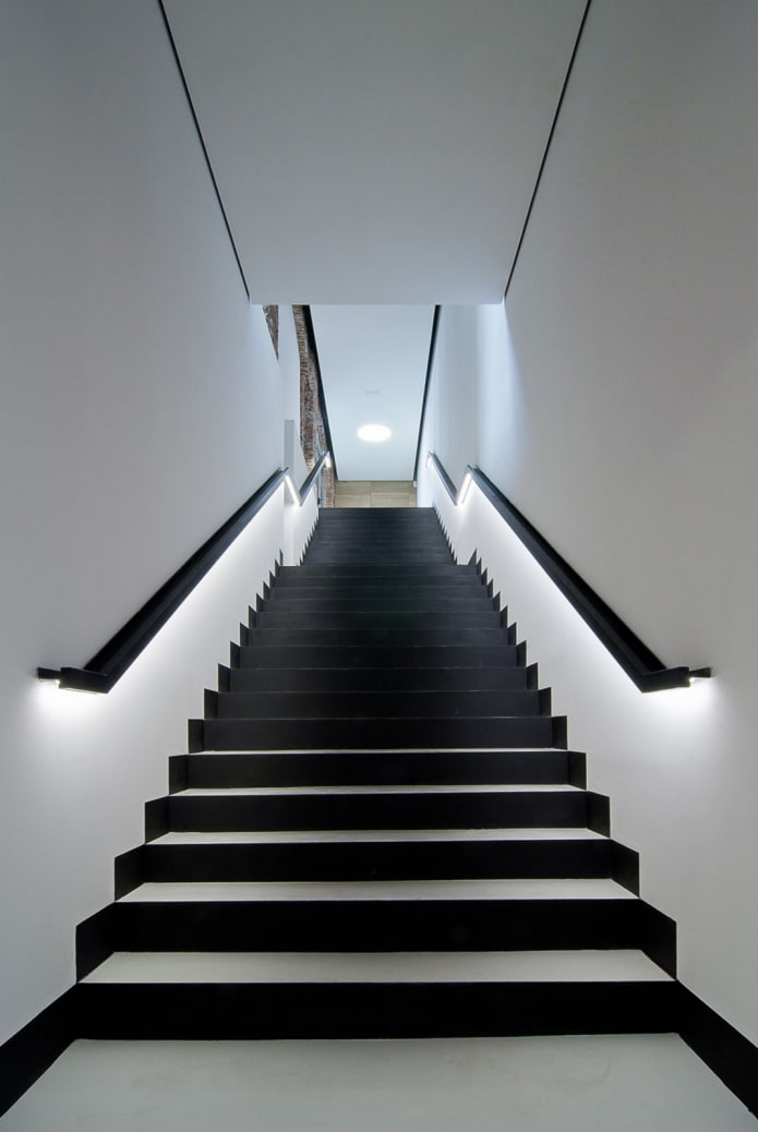 namo laiptai su apšviestu turėklu