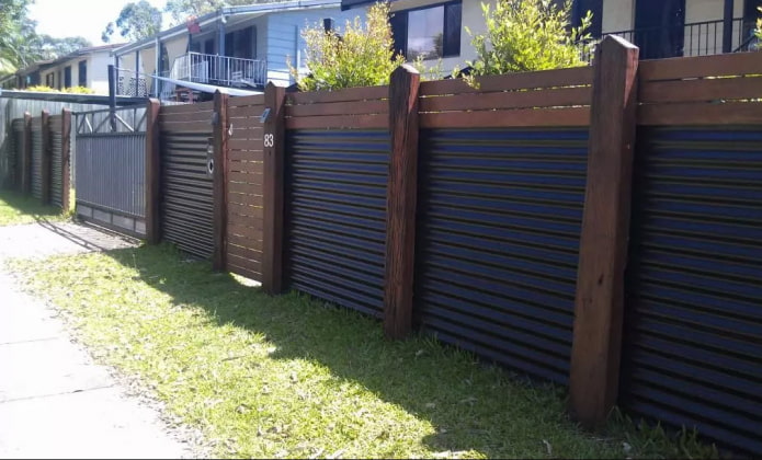 Hàng rào làm bằng tấm định hình với các trụ gỗ