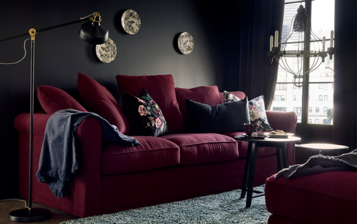 viininpunainen sohva mustalla seinällä