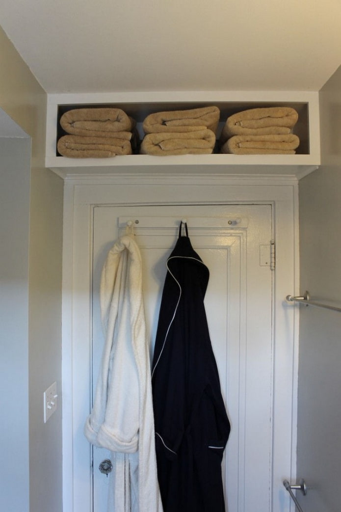 plank met handdoeken boven de deur