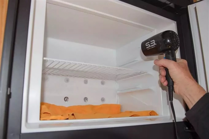 afrimning af køleskabet med en hårtørrer