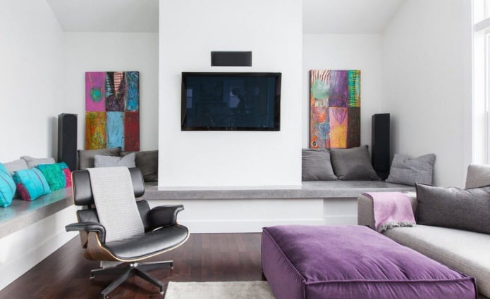moderni olohuone värikkäillä maalauksilla ja ottomaanilla