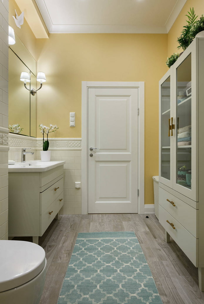 phòng tắm với những bức tường màu vàng nhạt và đồ nội thất màu trắng
