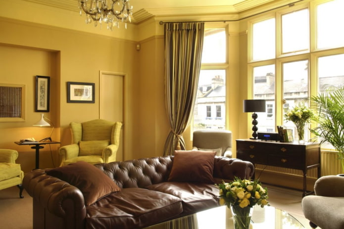 salon jaune foncé avec canapé en cuir marron