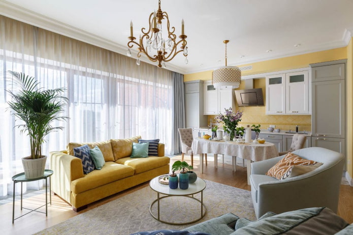 dzeltens dīvāns, kas viesistabā atkārto sienas toni