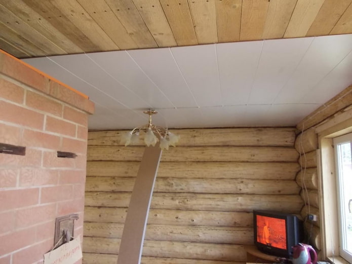 installation de panneaux de plafond en plastique dans un chalet en bois