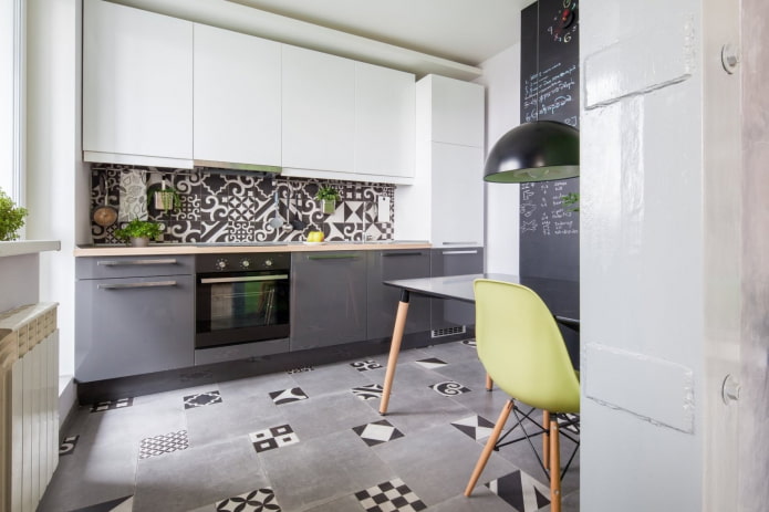 sivá a biela kuchyňa s mozaikou na podlahe a na zástere