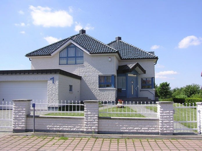 facciata bianca strutturata di una casa di mattoni