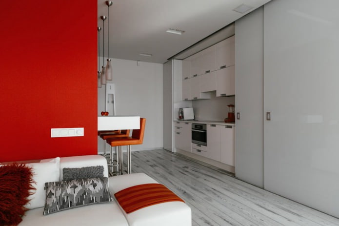 Barový pult v interiéru kuchyně a obývacího pokoje v bílých a červených tónech